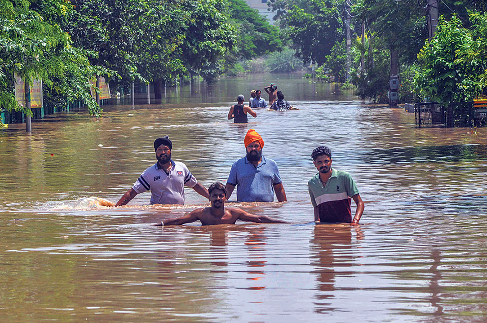 ਪਟਿਆਲਾ ਸ਼ਹਿਰ ਦੀ ਇਕ ਸੜਕ ’ਤੇ ਭਰੇ ਪਾਣੀ ਵਿੱਚੋਂ ਲੰਘ ਕੇ ਸੁਰੱਖਿਅਤ ਥਾਂ ਵੱਲ ਜਾਂਦੇ ਹੋਏ ਲੋਕ।