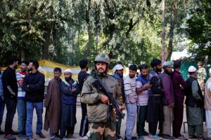 ਦੱਖਣੀ ਕਸ਼ਮੀਰ ਦੇ ਕੋਕਰਨਾਗ ਵਿਚ ਬੁੱਧਵਾਰ ਨੂੰ ਵੋਟਾਂ ਪਾਉਣ ਲਈ ਕਤਾਰ ਵਿਚ ਖੜ੍ਹੇ ਵੱਡੀ ਗਿਣਤੀ ਵੋਟਰ ਅਤੇ ਮੁਸਤੈਦੀ ਨਾਲ ਤਾਇਨਾਤ ਇਕ ਸੁਰੱਖਿਆ ਜਵਾਨ। -ਫੋਟੋ: ਰਾਇਟਰਜ਼